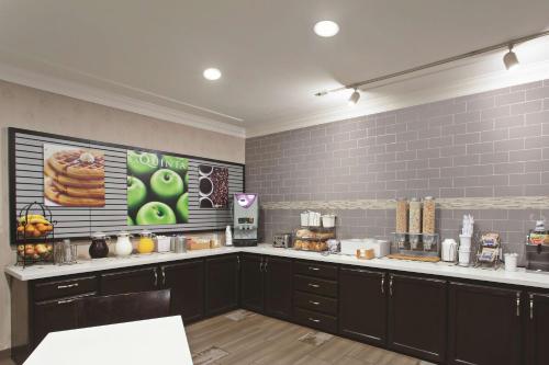 a kitchen with black cabinets and a counter top at La Quinta by Wyndham Los Banos in Los Banos
