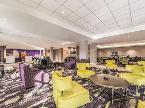 a lobby with yellow and purple chairs and tables at La Quinta by Wyndham Cincinnati Sharonville in Sharonville