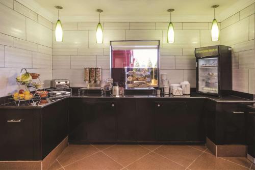 a kitchen with black cabinets and a counter top at La Quinta Inn & Suites by Wyndham Louisville East in Louisville