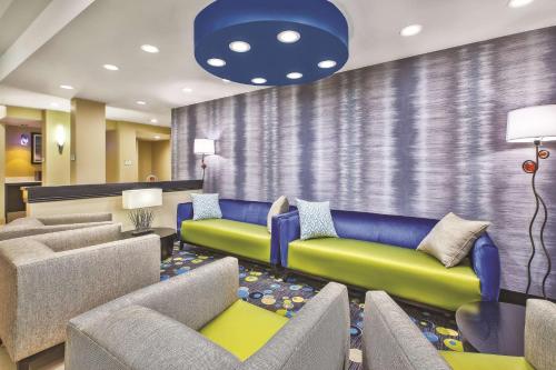a waiting room with couches and chairs in a lobby at La Quinta by Wyndham Niagara Falls in Niagara Falls
