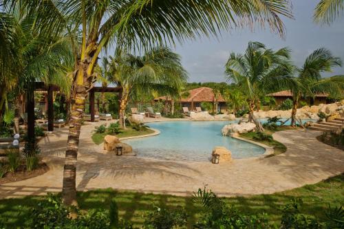 a swimming pool in a resort with palm trees at Royal Isabela in Isabela