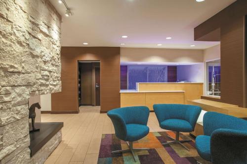 a waiting room with blue chairs and a counter at La Quinta by Wyndham Manassas Battlefield in Manassas