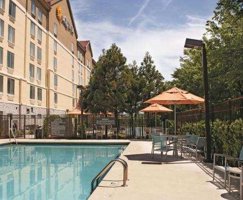 - Piscina con mesa, sillas y sombrilla en La Quinta by Wyndham Atlanta Airport North en Atlanta