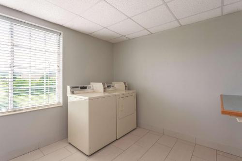 a laundry room with a refrigerator and a window at La Quinta by Wyndham Knoxville North I-75 in Knoxville
