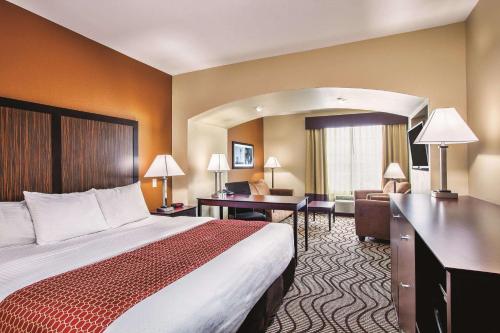 a hotel room with a bed and a desk at La Quinta by Wyndham Cotulla in Cotulla