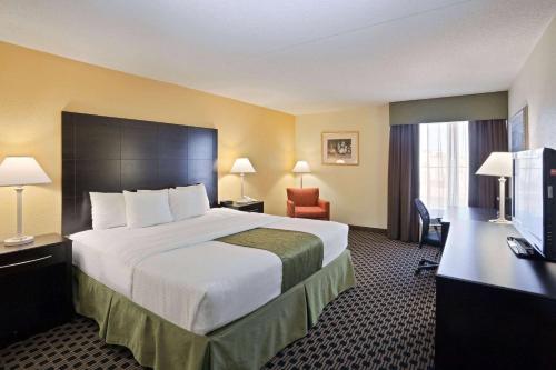 a hotel room with a large bed and a television at La Quinta by Wyndham Salina in Salina