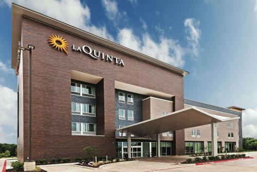 a hotel building with a sun sign on it at La Quinta by Wyndham College Station South in College Station