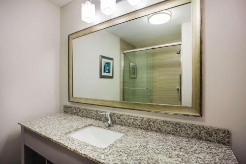 a bathroom with a sink and a large mirror at La Quinta by Wyndham St. Paul-Woodbury in Woodbury
