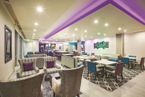 a restaurant with tables and chairs and purple ceilings at La Quinta by Wyndham McAllen La Plaza Mall in McAllen