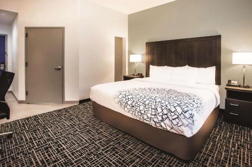 a hotel room with a large bed and a door at La Quinta by Wyndham Inner Harbor Downtown in Baltimore