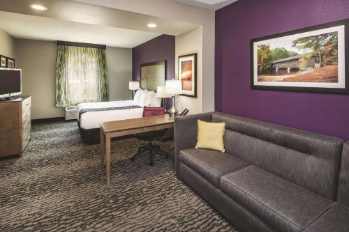 a hotel room with a couch and a bed at La Quinta by Wyndham Milledgeville in Milledgeville