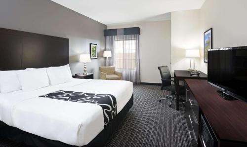 a hotel room with a bed and a flat screen tv at La Quinta by Wyndham Billings in Billings