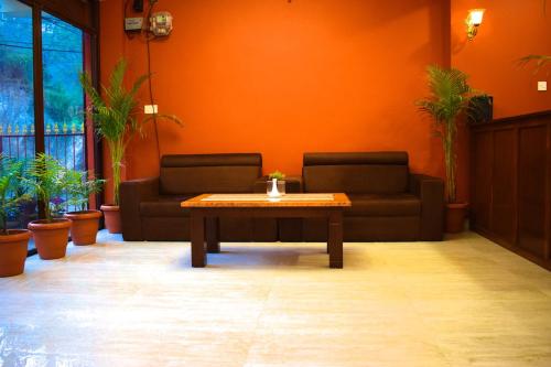 a living room with a table and a couch at Hotel Nagarkot Inn in Nagarkot