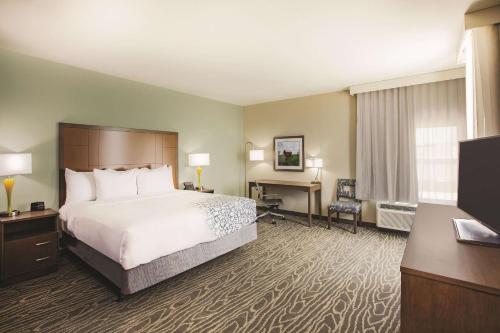a hotel room with a bed and a desk at La Quinta by Wyndham Wichita Northeast in Wichita