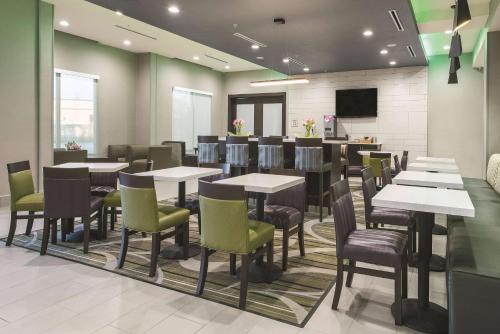 a restaurant with tables and chairs and a television at La Quinta by Wyndham Fort Worth West - I-30 in Fort Worth