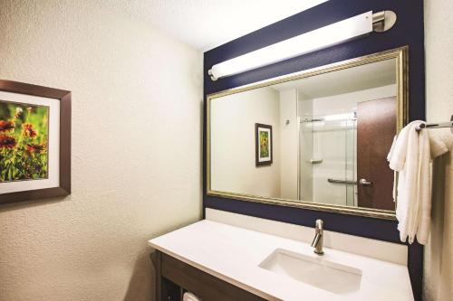 a bathroom with a sink and a large mirror at La Quinta by Wyndham Wichita Northeast in Wichita