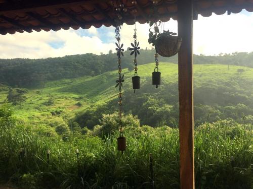 Pilões的住宿－Chalé com Vista Privilegiada，客房享有绿色田野的景致。