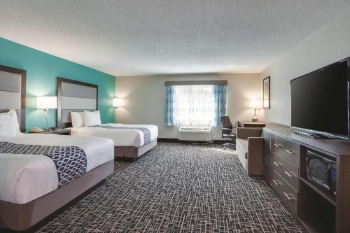 a hotel room with two beds and a flat screen tv at La Quinta by Wyndham Batavia in Batavia