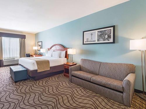 a hotel room with a bed and a couch at La Quinta by Wyndham Mathis in Mathis