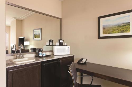 a hotel room with a sink and a microwave at La Quinta by Wyndham Los Banos in Los Banos