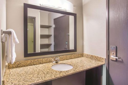 a bathroom with a sink and a mirror at La Quinta by Wyndham O'Fallon, IL - St. Louis in O'Fallon