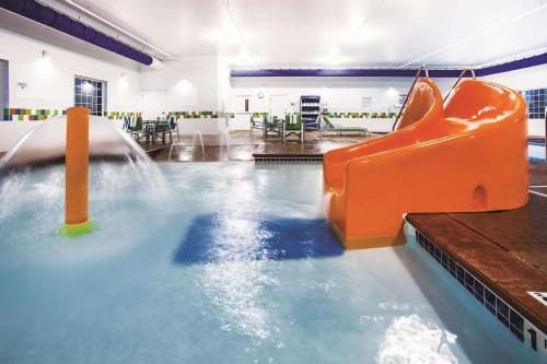 an indoor swimming pool with an orange water slide at La Quinta by Wyndham St. Paul-Woodbury in Woodbury