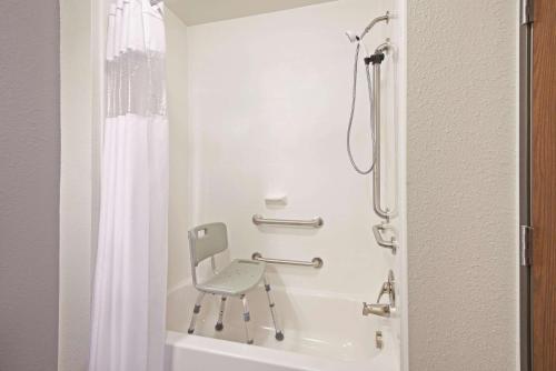 a shower with a chair in a bathroom at La Quinta by Wyndham Morgantown in Morgantown