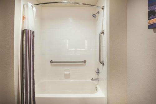 a bath tub in a bathroom with a shower at La Quinta by Wyndham Dallas - Richardson in Dallas