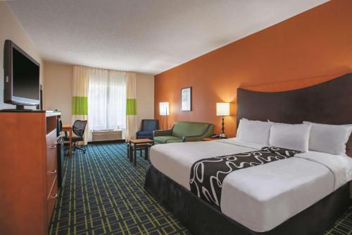 マナッサスにあるLa Quinta by Wyndham Manassas Battlefieldの大型ベッド1台、薄型テレビが備わるホテルルームです。