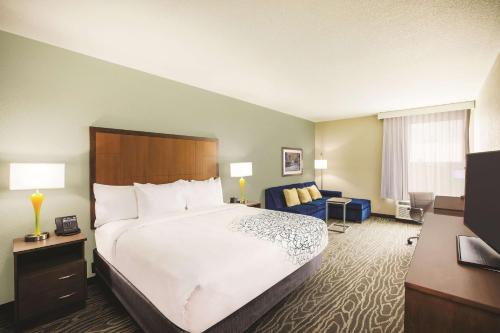 a hotel room with a large bed and a couch at La Quinta by Wyndham Wichita Northeast in Wichita