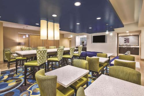 a restaurant with tables and chairs and a television at La Quinta by Wyndham Niagara Falls in Niagara Falls