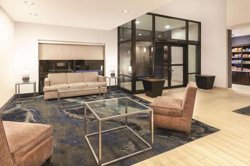 a living room with two couches and a glass table at La Quinta by Wyndham Philadelphia Airport in Essington