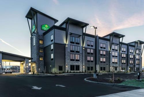 - un grand bâtiment avec un panneau vert dans l'établissement La Quinta Inn & Suites by Wyndham Walla Walla, à Walla Walla