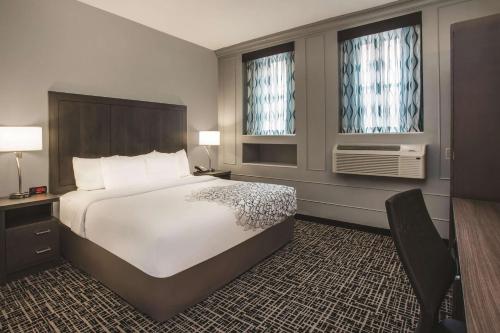 a hotel room with a large bed and two windows at La Quinta by Wyndham Inner Harbor Downtown in Baltimore