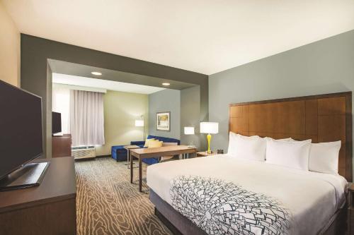 a hotel room with a large bed and a desk at La Quinta by Wyndham Wichita Northeast in Wichita
