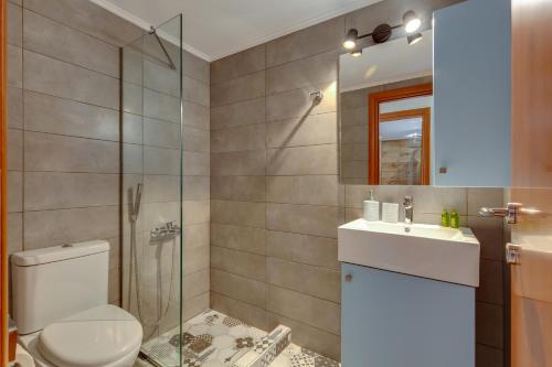 a bathroom with a toilet and a sink and a shower at Ikia Aretousa in Kato Daratso