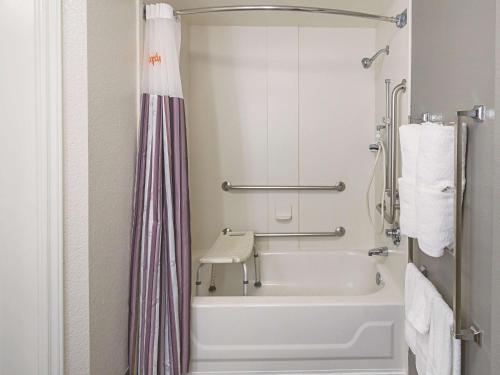 a bathroom with a tub and a shower curtain at La Quinta by Wyndham Denver Englewood Tech Ctr in Greenwood Village
