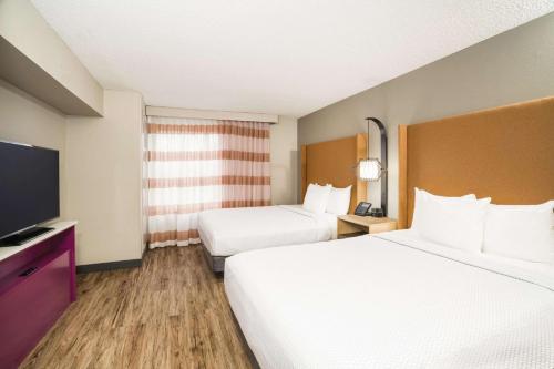 a hotel room with two beds and a flat screen tv at La Quinta by Wyndham Chattanooga North - Hixson in Hixson