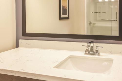 a bathroom with a sink and a mirror at La Quinta by Wyndham Morgan Hill-San Jose South in Morgan Hill