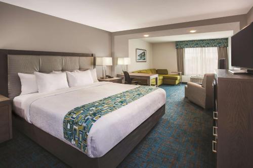 a hotel room with a large bed and a couch at La Quinta by Wyndham St. Paul-Woodbury in Woodbury