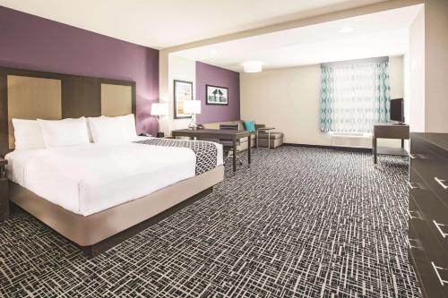 a hotel room with a bed and a desk at La Quinta by Wyndham Dallas Plano - The Colony in The Colony