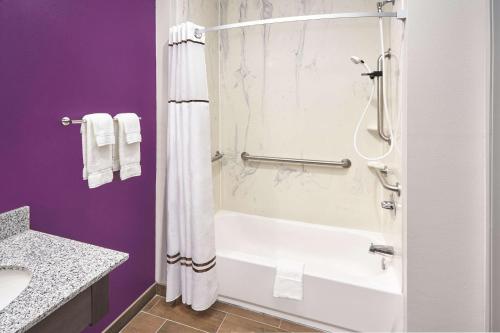 a bathroom with a white bath tub and a sink at La Quinta by Wyndham Springfield IL in Springfield