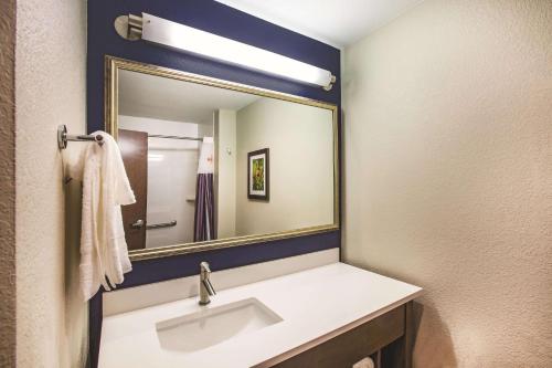 a bathroom with a sink and a mirror at La Quinta by Wyndham Wichita Northeast in Wichita