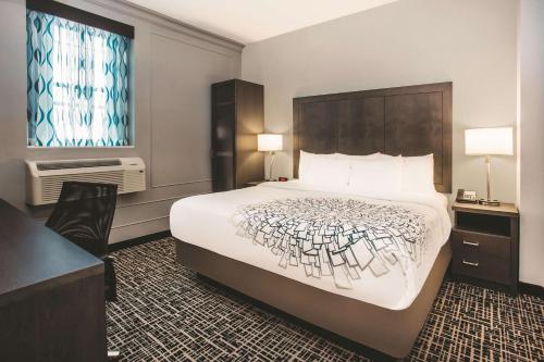 a hotel room with a large bed and a desk at La Quinta by Wyndham Inner Harbor Downtown in Baltimore
