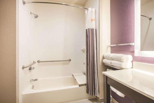 a bathroom with a white tub and a sink at La Quinta by Wyndham Dallas Plano - The Colony in The Colony