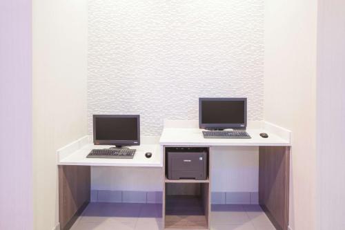 two computers are sitting on a white desk at La Quinta by Wyndham San Marcos Outlet Mall in San Marcos