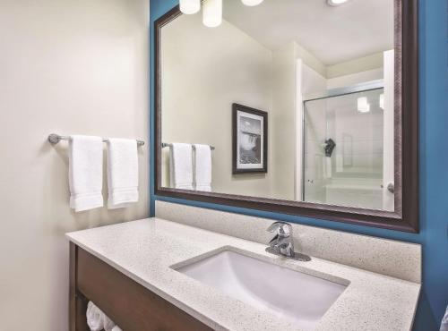 a bathroom with a sink and a mirror at La Quinta by Wyndham Niagara Falls in Niagara Falls