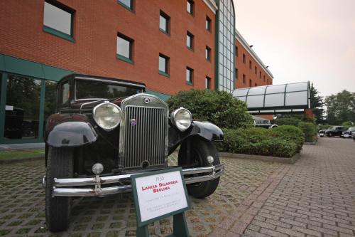 an old car is on display in front of a building at Hotel Della Rotonda in Saronno