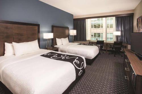a hotel room with two beds and a desk at La Quinta by Wyndham Chicago Downtown in Chicago