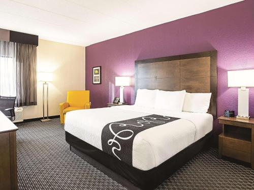 a hotel room with a large bed and purple walls at La Quinta by Wyndham Baltimore N / White Marsh in Baltimore